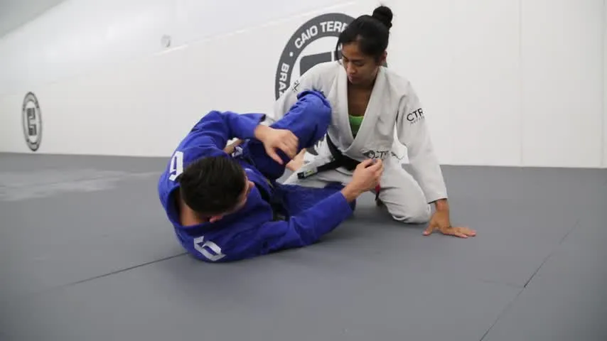 A half-guard player propping up the shin shield — the defense the cradle is built to pass